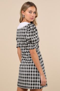 Playful glamour meets academic aesthetics with the Sister Jane Quill Check Black Plaid Puff Sleeve Rhinestone Mini Dress! Lightweight woven fabric boasts a plaid, checker-like design as it shapes short puff sleeves that frame a bodice with a Peter Pan-style collar that features scalloped edges, sparkly rhinestones, and a removable, rhinestone-encrusted pin in the shape of a cute bow. Functional button placket (with rhinestone buttons) secures at the front of the bodice and continues down between Chic Short Sleeve Plaid Mini Dress, Gingham Plaid Mini Dress, Black Cotton Plaid Mini Dress, Rhinestone Mini Dress, Collar Mini Dress, Plaid Mini Dress With Button Closure, Fitted Houndstooth Plaid Mini Dress, Sister Jane, Cute Bow