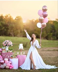 a woman in a white dress is holding some balloons