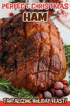 a christmas ham is sitting on a plate with holly and cranberries around it