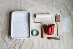 the contents of a paintbrush, brush, and other items laid out on a sheet