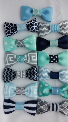 several different types of bow ties laid out on a white tablecloth with blue and gray designs