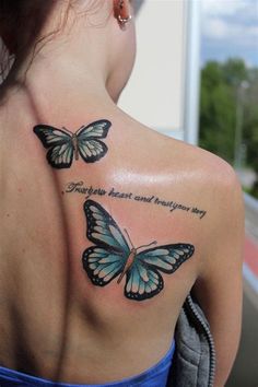 the back of a woman's shoulder with two butterflies on it