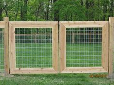 three wooden frames with wire on them in the grass