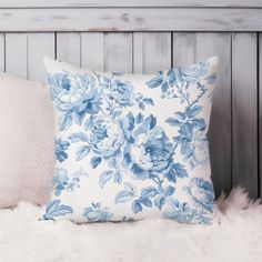 a blue and white flowered pillow sitting on top of a furnishing area