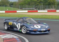 a blue race car driving around a track