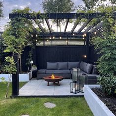 an outdoor living area with couches, tables and lights in the middle of it