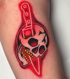 a skull with a knife on it's arm