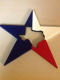 a red, white and blue star cut out of wood sitting on top of a table