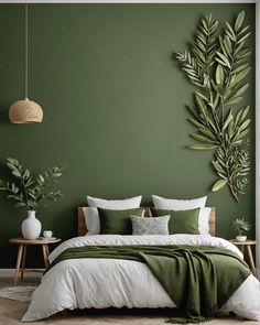 a bedroom with green walls, white bedding and plants on the headboard wall