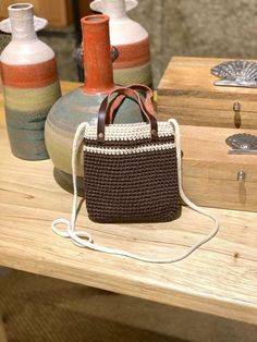 This everyday-style, handmade cotton small crossbody bag is perfect for carrying your essentials during a day out. The bag features a soft cotton crochet body in brown with a white accent at the opening. It includes a genuine leather handle for hand-carrying and a woven cotton strap for crossbody wear. Lightweight yet durable, it's ideal for daily use. Inside, the crochet bag is lined with cotton and includes an inner pocket, offering a soft and protective space for your phone and other essentia Casual Brown Crochet Bag With Adjustable Strap, Casual Brown Crochet Crossbody Bag, Brown Crochet Tote Bag For Mobile Phone, Brown Crochet Bag With Adjustable Strap For Everyday Use, Brown Crossbody Crochet Bag For Daily Use, Brown Crochet Crossbody Bag For Daily Use, Casual Brown Handmade Shoulder Bag, Brown Crochet Mobile Phone Bag For Everyday Use, Brown Crochet Mobile Phone Bag