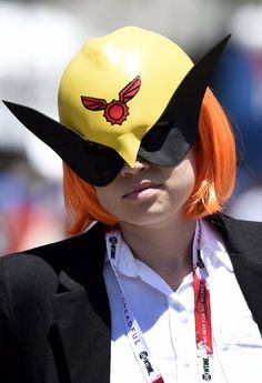 a woman with orange hair wearing a yellow hat and black cat ears on her head