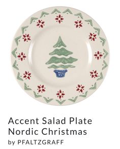 a white plate with green and red designs on the front, and an image of a christmas tree on it