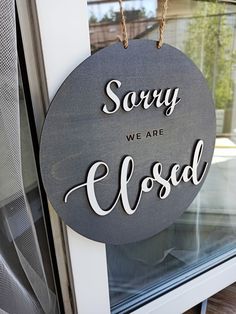 a sign that says sorry we are closed hanging from the side of a window sill