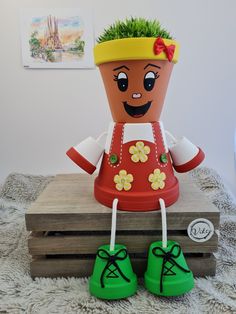 a potted plant sitting on top of a wooden box with green shoes next to it