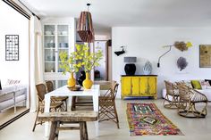 a living room filled with furniture and yellow vases on top of a white table