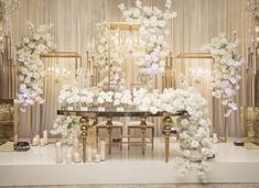 a table with white flowers and candles on it