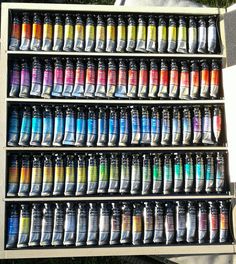 a display case filled with lots of different colored paint tubes on top of each other