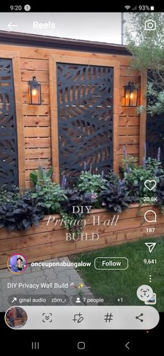 a wooden fence with plants and lights on it