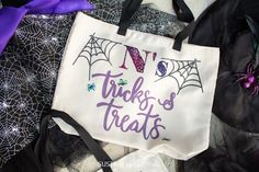 there is a trick or treat bag on top of some halloween fabric and spider webs