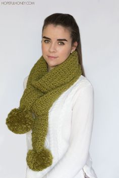 a woman wearing a green scarf and a white sweater