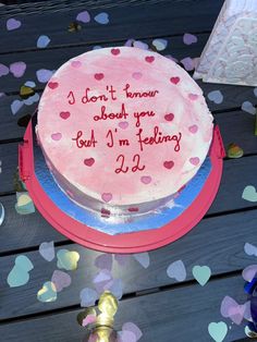 a birthday cake with writing on it sitting on top of a table surrounded by confetti