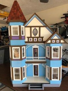 a blue doll house sitting on top of a wooden table