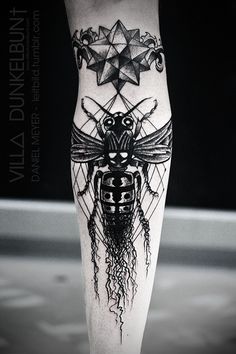 a black and white tattoo on the leg of a woman's leg with an insect