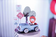 a cake with a car on top and street signs in the backgroung