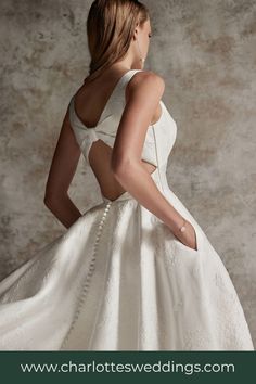 a woman in a white wedding dress with her back to the camera