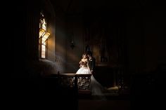 a bride and groom standing in front of a stained glass window at the end of their wedding day