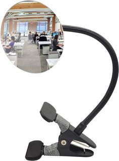 an image of a desk lamp that is attached to the side of a table with people sitting at tables in the background