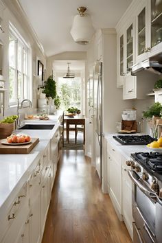 a kitchen filled with lots of white counter top space and wooden flooring next to an oven