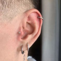 a close up of a person with piercings on their ears and behind the ear