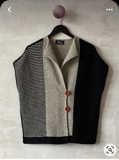 a black and white vest hanging on a wall next to a buttoned up shirt