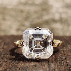 an old - fashioned diamond ring sits on a piece of wood