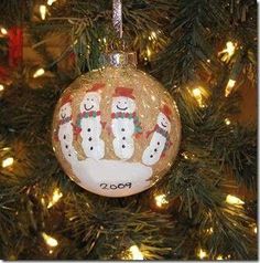 a christmas ornament with snowmen on it that says handprint ornaments what a great idea