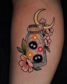 an image of a tattoo with flowers and moon in a jar on the thigh or leg