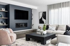 a living room filled with furniture and a flat screen tv mounted on the wall above a fireplace