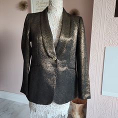 Make A Statement In This Stunning Eye-Catching Ann Klein Unique Blazer Small Almost A Fish Scale Pattern With Metallic Shiny Muted Gold And Black. 88% Polyester 12% Metallic Working Hidden Pockets One Button Closure Lined And Built In Light Shoulder Pads Chest Lying Flat 19.5 Arm Inseam 18 Length Down Back 27.5 Shoulders 15 Gold Notch Lapel Outerwear For Party, Gold Notch Lapel Outerwear For Evening, Tailored Gold Outerwear With Lapel Collar, Gold Winter Workwear Blazer, Gold Winter Blazer For Work, Gold Blazer For Winter Workwear, Gold Fitted Blazer With Lapel Collar, Gold Fitted Outerwear For Work, Fitted Gold Outerwear For Work