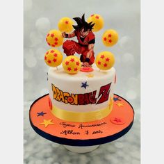 a birthday cake decorated with an image of gohan on top and balloons in the shape of stars