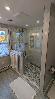 a bathroom with a walk in shower next to a window