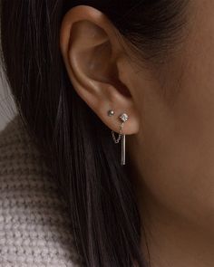 a close up of a person wearing a pair of ear piercings on their ears