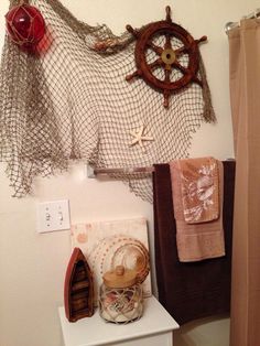 there are many items on the shelf in this bathroom that is decorated with net and wood