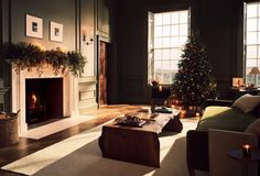 a living room filled with furniture and a fire place in front of a christmas tree