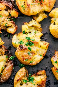 baked potatoes with herbs and seasoning on a baking sheet, ready to be eaten