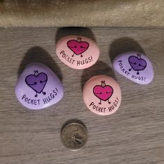 four rocks with the words pocket hugs written on them next to a quarter dollar coin