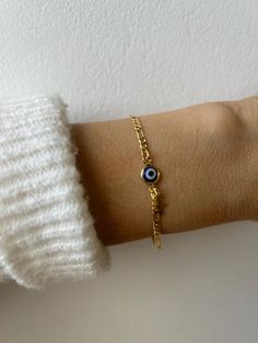 Brush away negative energy and stay protected with this dainty evil eye bracelet! D E T A I L S *It features a gold filled evil eye charm (12 x 6.5mm) in traditional blue *on a high quality 18k gold filled Figaro chain in yellow gold. *Gold filled is a wonderful alternative to solid gold and unlike gold plating does not rub off. *A tiny gold filled cross dangles from the chain. *It closes with a gold filled lobster clasp. *Choose the length from the drop down menu. Use the length guide as a refe Everyday Yellow Gold Evil Eye Bracelets, Dainty Evil Eye Bracelet For Everyday, Dainty Yellow Gold Bracelet With Evil Eye Detail, Dainty Yellow Gold Bracelet With Evil Eye, Minimalist Gold Bracelets With Evil Eye, Dainty Evil Eye Bracelet With Adjustable Chain, Gold Minimalist Bracelet With Evil Eye, Minimalist Gold Bracelet With Evil Eye, Dainty Gold Evil Eye Bracelet, Adjustable