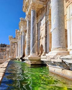 the water is green and there are many columns