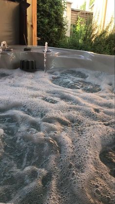 an outdoor hot tub with water running down it