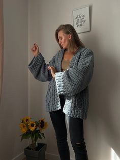 a woman standing in front of a window with her hand on her hip and looking at something